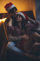 Obraz na płótnie Canvas Romantic couple in love feel happiness from their romance while spending Christmas together, woman and man enjoying perfect relationship in cozy home interior. High quality photo