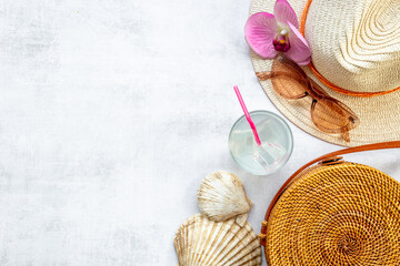 Woman's beach accessories flatlay with straw hat and rattan bag