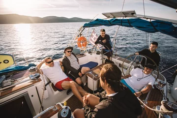 Fototapeten Group of friends enjoy sailboat ride © yossarian6