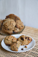 cookies in a jar and cookies on a plate.
a bite taken out of one cookie