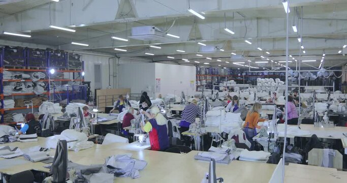 Working process in the workshop of a garment factory. Work at a sewing factory. Seamstresses work at a textile factory