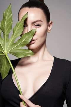 Portrait of a beautiful woman with grass leaves in her hands