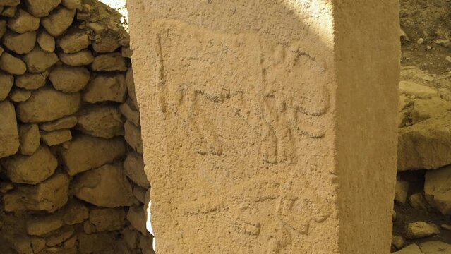 Tilt-down shot of carvings on stone pillar, Gobekli Tepe archaeological site