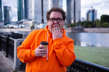 Funny fat man drinking coffee on the street.