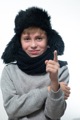 Winter hat with earflaps and scarf, portrait of a boy in winter clothes.