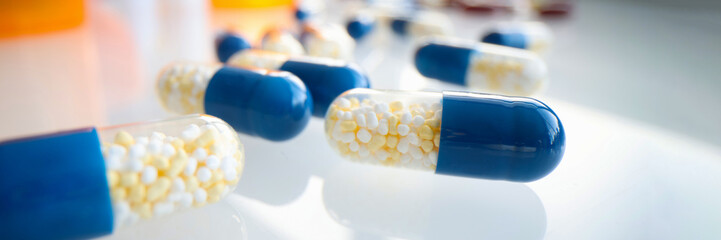 White blue capsules lie on the table, blurry - obrazy, fototapety, plakaty