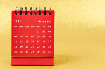 The Red December 2022 Monthly desk calendar for 2022 year on golden color background.
