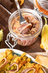 Anchovies in a jar, on a wooden rustic background. Traditional italian food of the south of italy and sardinia. Anchovy Fillets. small but herring. Copy space