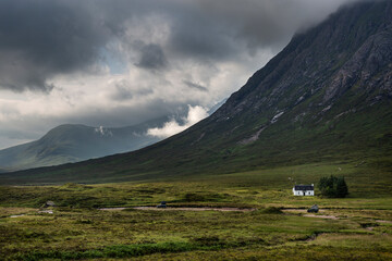 Small white cottage at the foot of Buachaille Etive Mor in Glencoe, Scotland © casavella