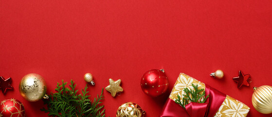 Christmas banner design. Row of Xmas decorations, gold and red baubles, fir branches, gift box on...