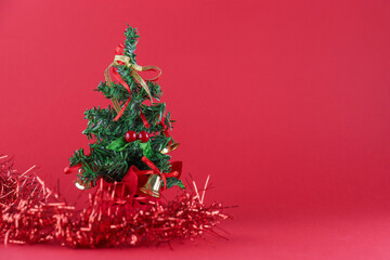 Spruce branches with Christmas decorations on a red monochromatic background