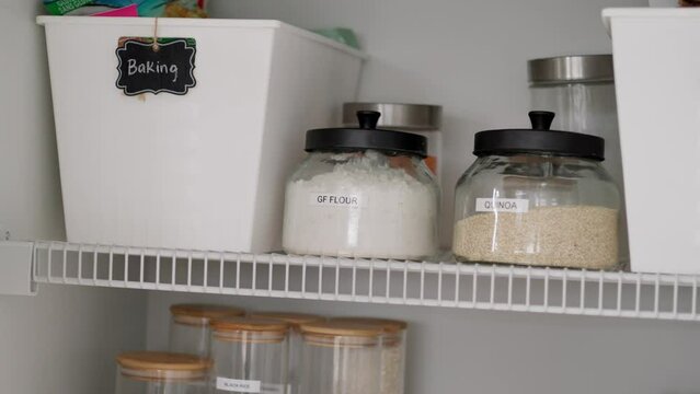 Woman restocking food cabinet, flour