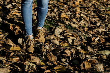 female legs in shoes walking in park