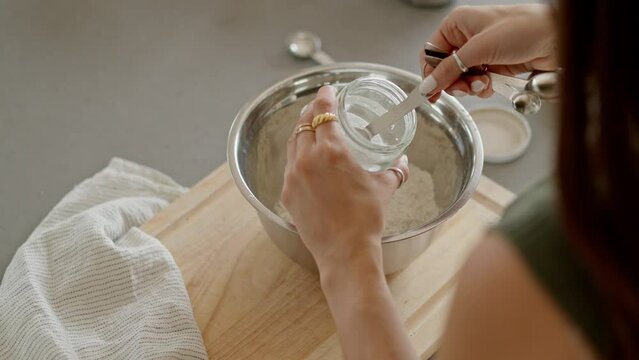 Top down, close up of girl measuring baking soda
