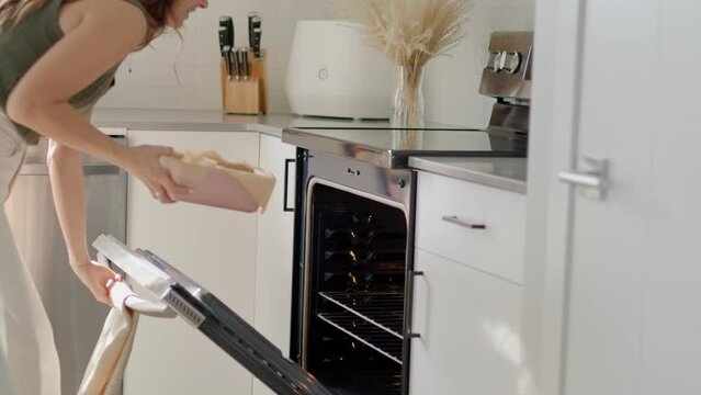 Girl placing fall baking recipe in oven