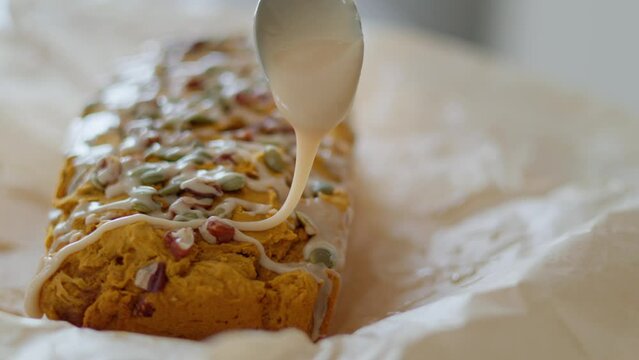 Close up tracking shot of icing on baking recipe, pumpkin loaf