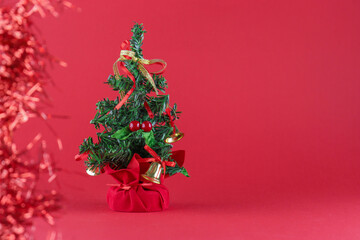 Spruce branches with Christmas decorations on a red monochromatic background
