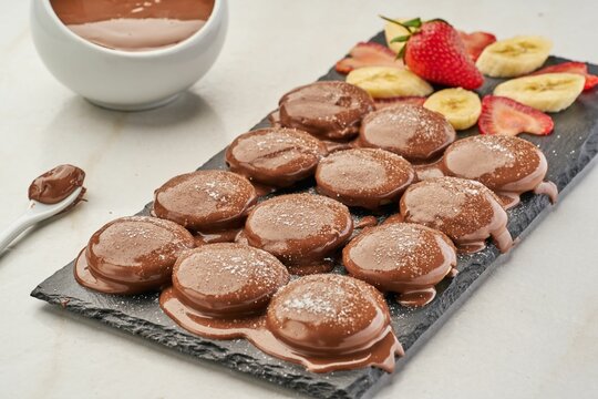 Mini Chocolate Pancakes With Sliced Banana And Strawberry On Board