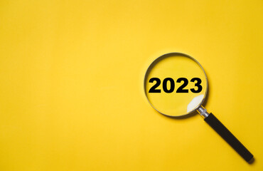 2023 year inside of magnifier glass for focus and concentrate of new business year , Merry...