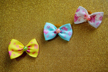 light blue, beige and yellow bows for the top notes of dogs with long hair lie on a golden...