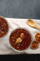 Bowl of homemade chocolate chia pudding, made with dark chocolate, chia seeds, orange juice and plant based milk. Top view.