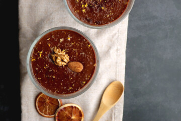 Bowl of homemade chocolate chia pudding, made with dark chocolate, chia seeds, orange juice and plant based milk. Top view.