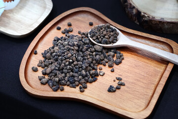 Chocolate pellets with wooden spoon on wooden plate and texture. confectionery raw materials.	