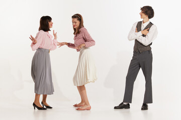 Fototapeta premium Dance. Expressive two woman and man in vintage retro style outfits dancing social dance isolated on white background. Timeless traditions, 60s ,70s american fashion style. Dancers look excited