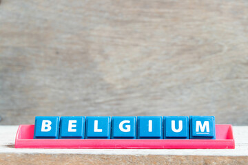 Tile alphabet letter with word belgium in red color rack on wood background