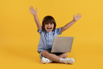 Great internet education. Excited little boy studying online on laptop and shouting hooray, enjoying distant learning