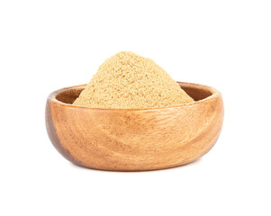 Wooden bowl with ground ginger root powder on a white background.