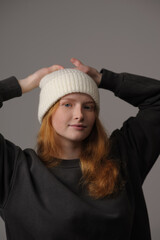 young girl model in white cap and gray coat isolated on grey background. Product photo mockup for fashion brands and marketplaces.