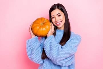 Portrait of attractive cheerful girl holding pumpkin bonding enjoying isolated over pink pastel...
