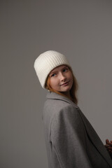 young girl model in white cap and gray coat isolated on grey background. Product photo mockup for fashion brands and marketplaces.