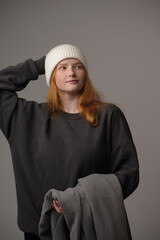 young girl model in white cap and gray coat isolated on grey background. Product photo mockup for fashion brands and marketplaces.