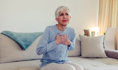 Female with chest pain. Senior woman suffering from heartburn or chest discomfort symptoms. Acid reflux or Gastroesophageal reflux disease (GERD) concept - obrazy, fototapety, plakaty