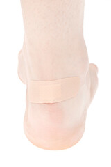 Human leg with medical adhesive wound plaster on ankle isolated on white background. first aid bandage