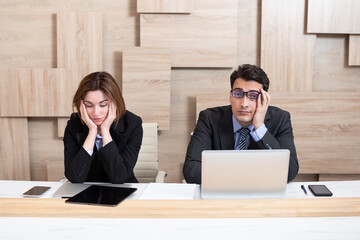 Stressed male and female business persons sitting at desk, hard thinking about problem. Businessman...