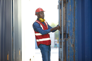 Fototapeta na wymiar African factory worker or foreman opening the container door in warehouse storage