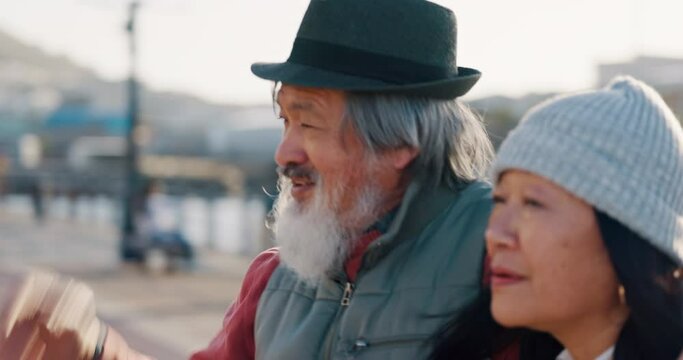Senior asian couple, pointing or walking by Amsterdam city water port on holiday, vacation or retirement break. Talking elderly man or woman in love, trust bond or security in tourist travel location