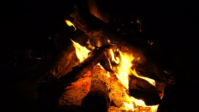 Beautiful shot of camp and fireplace fire burning in the dark at night.