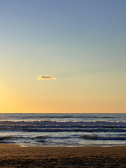 Fototapeta na wymiar nuvola solitaria su mare d'inverno al tramoto