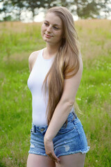 Fototapeta na wymiar Beautiful young woman enjoys summer in nature