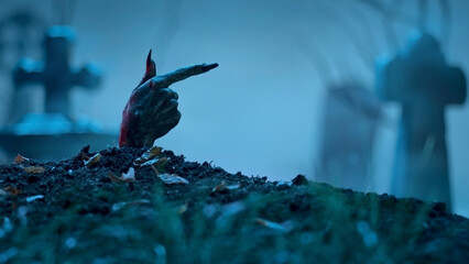 Zombie hand pointing to something out of grave. Holiday event halloween concept