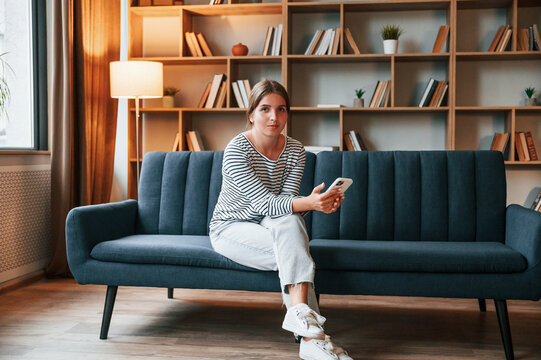 Young Woman Is Sitting On The Sofa In The Apartment