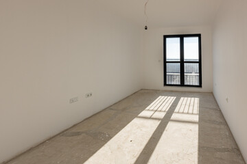 New empty room under construction. Plaster walls. New home. Concrete walls. Interior renovation.