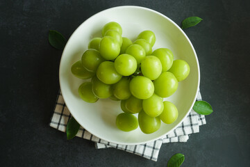 bunch of green grapes on a dark table - 539198471