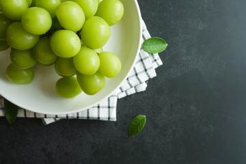 bunch of green grapes on a dark table - 539198476