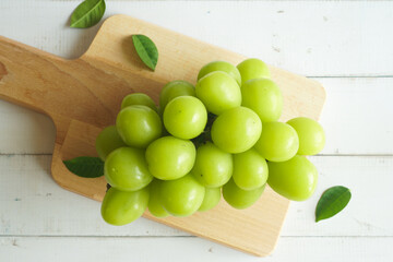 bunch of green grapes on a white wooden table - 539198493