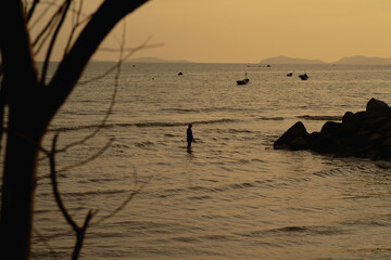 Sunrise on the beach with fisherman